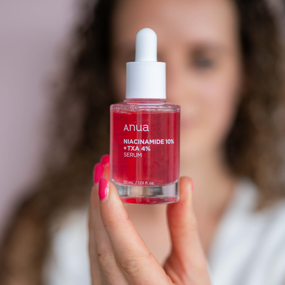 Persoon houdt Anua Niacinamide 10% + TXA 4% Dark Spot Correcting Serum voor het gezicht