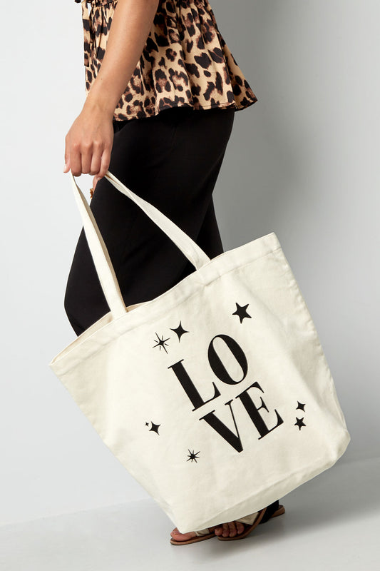 Canvas shopper met de tekst LOVE vastgehouden door een model