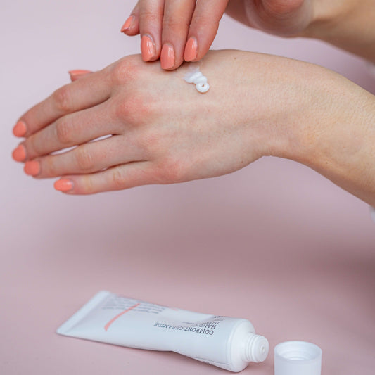 Persoon brengt COSRX Balancium Comfort Ceramide Intense Soothing Hand Cream aan op de handen