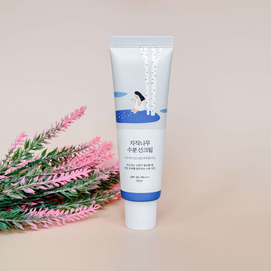 Round Lab Birch Juice Moisturizing Sun Cream SPF50+ PA++++ naast bloemen