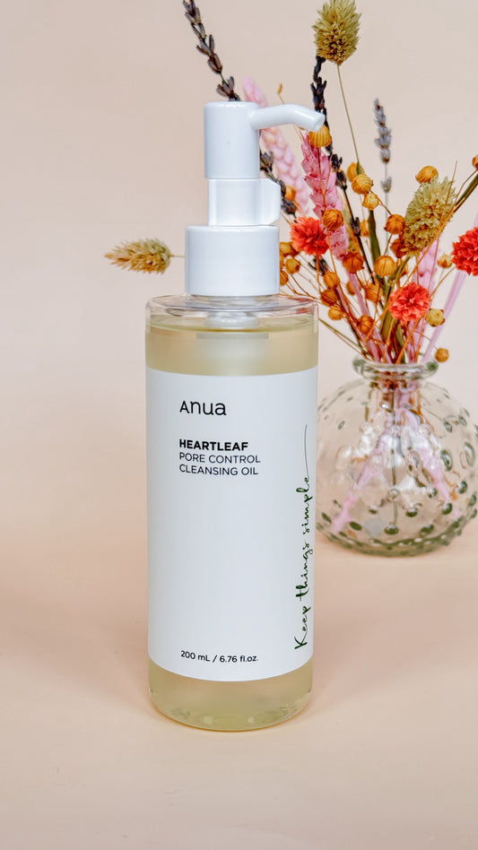 Anua Heartleaf Pore Control Cleansing Oil naast bloemen