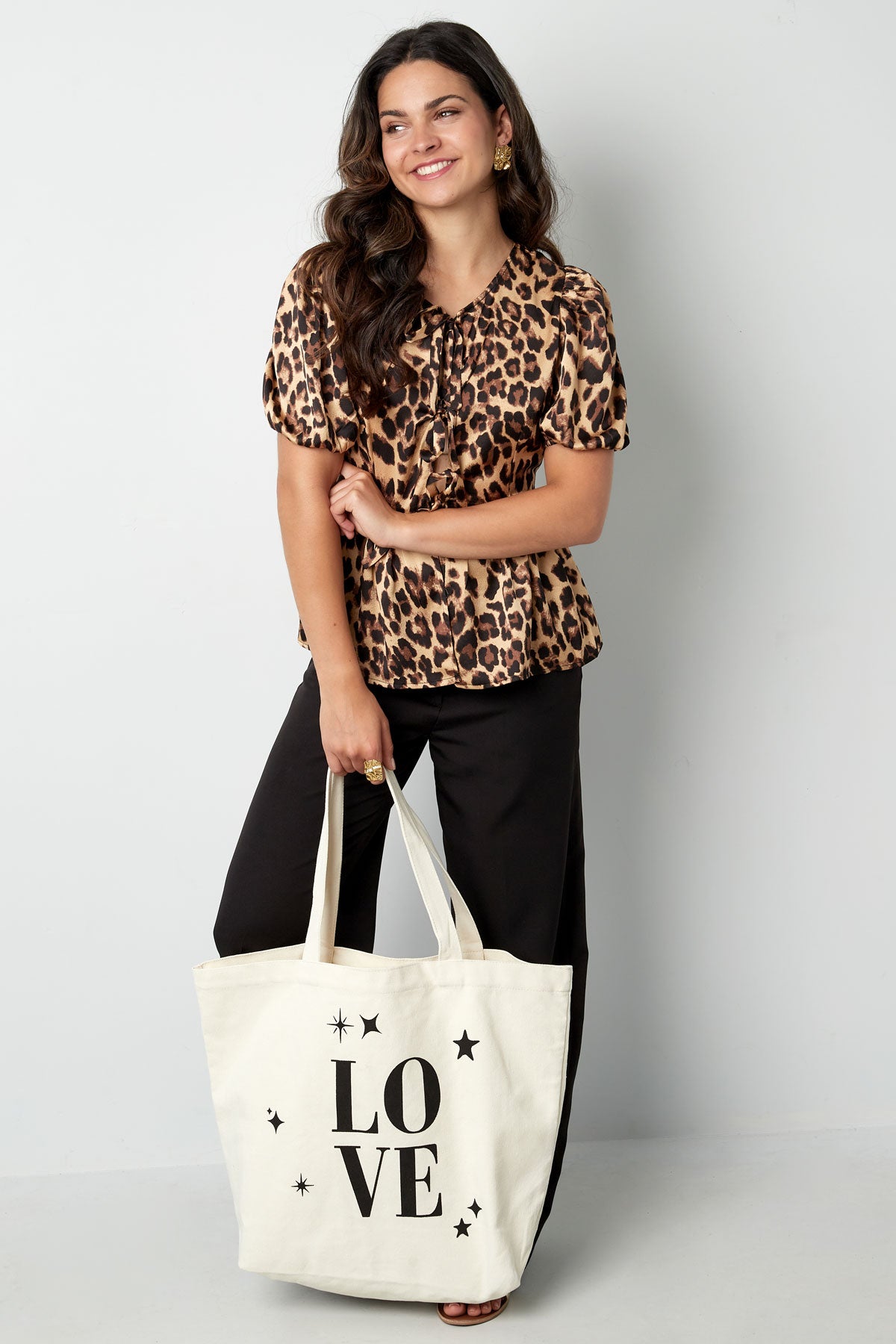 Canvas shopper met de tekst LOVE vastgehouden door een model