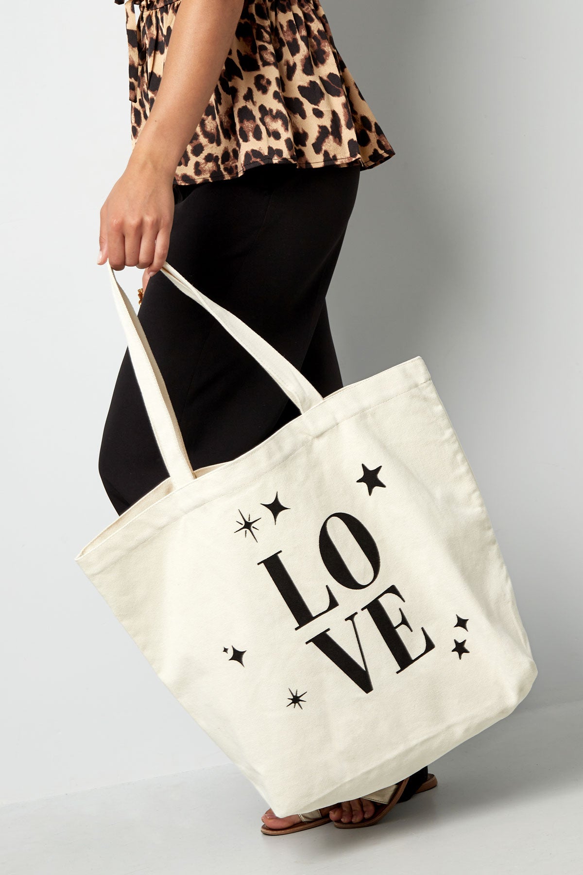 Canvas shopper met de tekst LOVE vastgehouden door een model