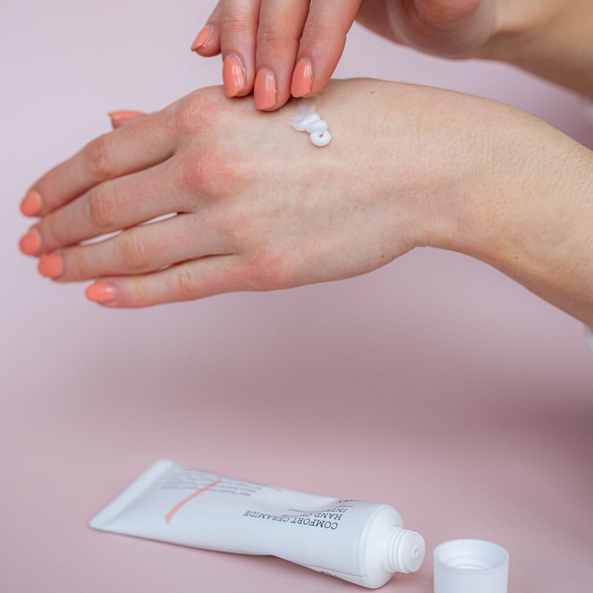 Persoon brengt COSRX Balancium Comfort Ceramide Intense Soothing Hand Cream aan op de handen