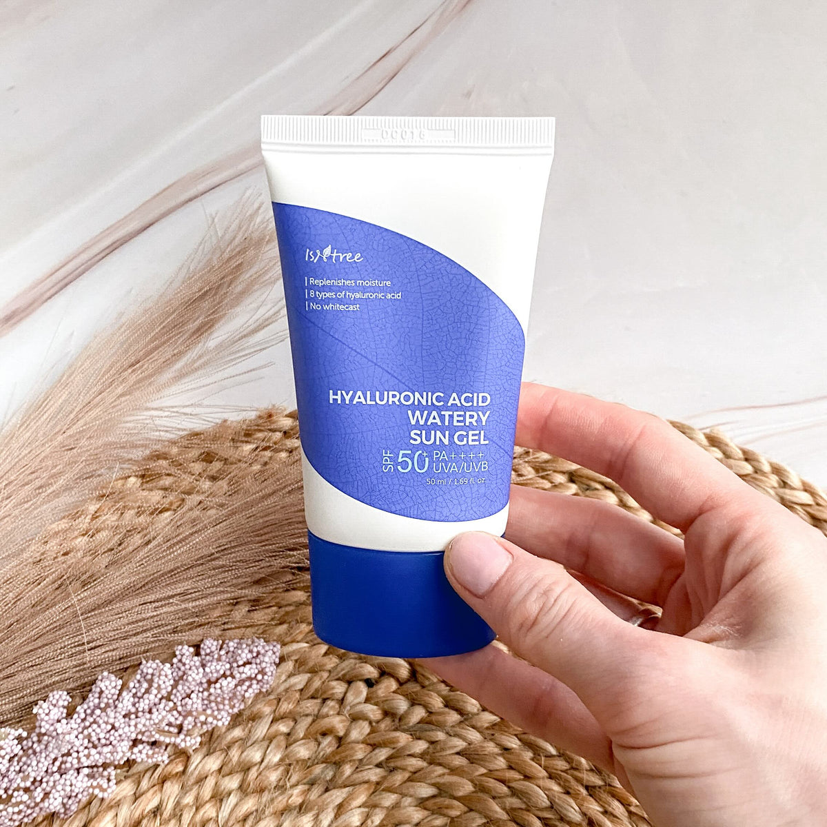 Persoon houdt de Isntree Hyaluronic Acid Watery Sun Gel SPF50+ PA++++ vast