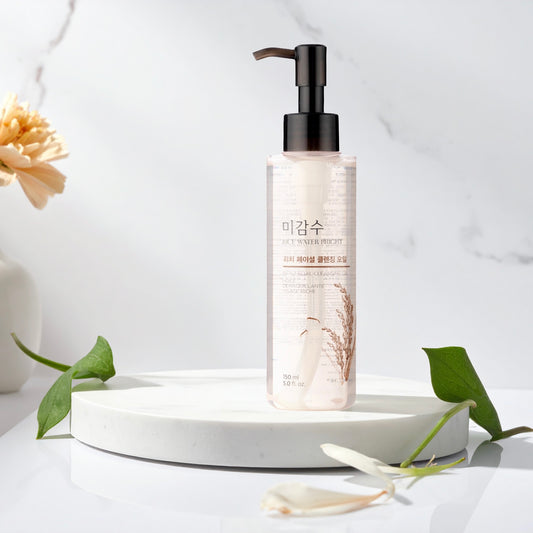 The Face Shop Rice Water Bright Rich Cleansing Oil op een witte ondergrond met groene bladeren