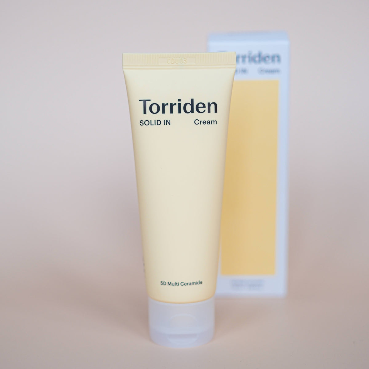 Torriden Solid In Ceramide Cream op een gele ondergrond